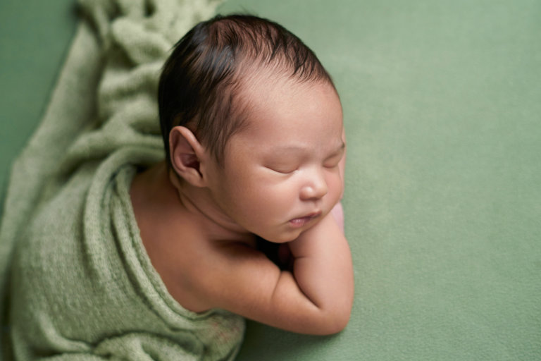Newborn baby boy on monochromatic green photography prop set for boy in Camden, NJ